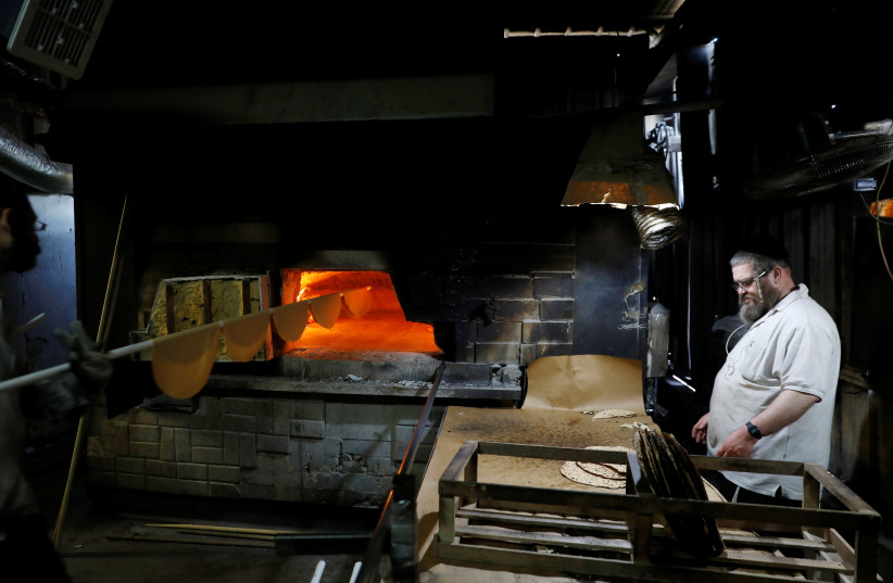 Ultra-Orthodox Jewish men prepare matza, a traditional unleavened bread eaten during the upcoming Jewish holiday of Passover, in Komemiyut, Israel (photo credit: REUTERS)