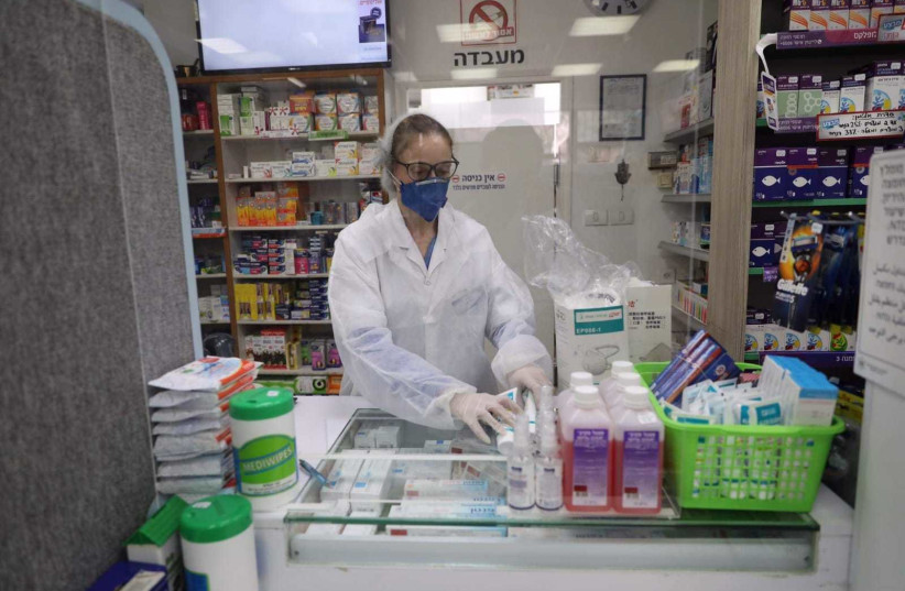 A pharmacy worker during the COVID-19 outbreak (photo credit: MARC ISRAEL SELLEM)