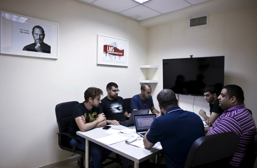 Firas Jabbour (C), founder and CEO of start-up Edunation, a social-learning platform, meets with his team at their offices in Nazareth, Israel (photo credit: REUTERS/NIR ELIAS)