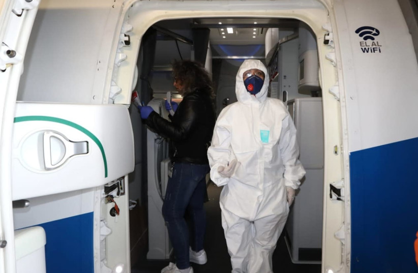 Staff disembark the El Al flight dressed in protective gear to protect them from contracting the coronavirus. (photo credit: SIVAN FARAG)
