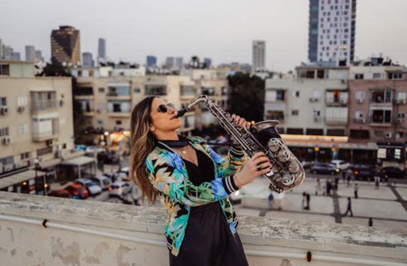 YARDEN KLAYMAN blows the sax during her rooftop solo gig in Tel Aviv’s Basel neighborhood last week.  (photo credit: IDAN HERSHKO & TEL AVIV MUNICIPALITY)