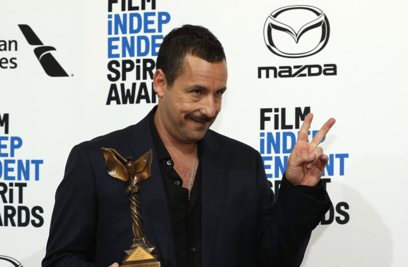 Adam Sandler poses backstage with his Best Male Lead award for "Uncut Gems." (photo credit: REUTERS/LUCAS JACKSON)