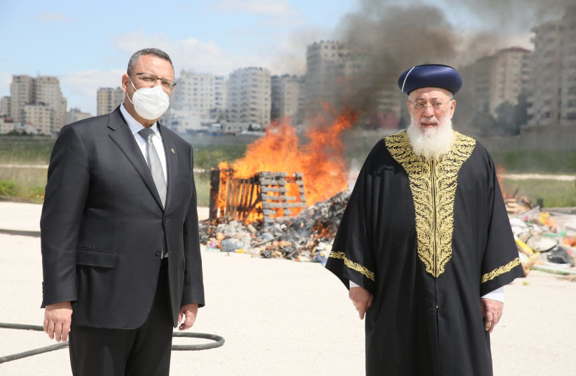 Mayor of Jerusalem Moshe Leon [L] and Rabbi of Jerusalem Shlomo Amar [R] with the burning of bread before Passover in the background  (photo credit: ARNON BOSSANI)
