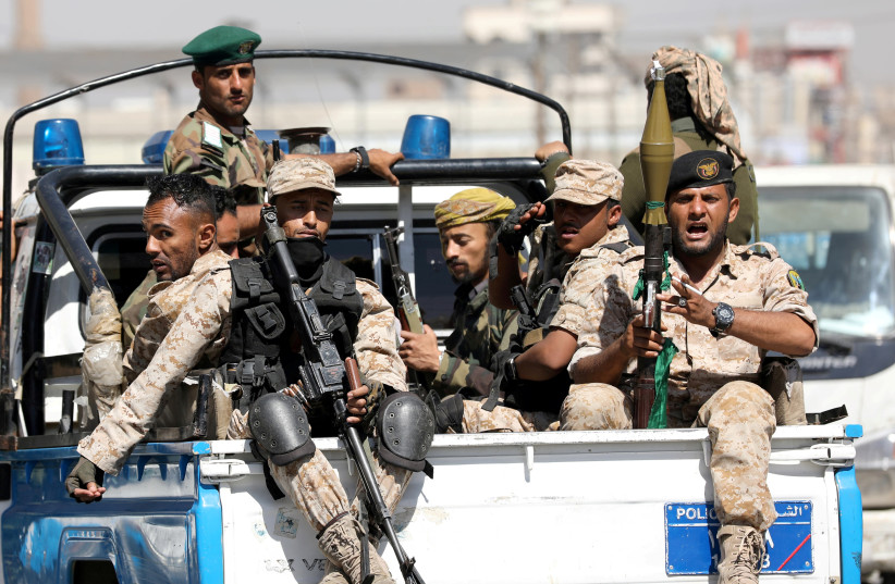 Houthi troops ride on the back of a police patrol truck after participating in a Houthi gathering in Sanaa, Yemen February 19, 2020. (photo credit: KHALED ABDULLAH/ REUTERS)