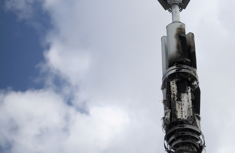 A telecommunications mast damaged by fire is seen in Sparkhill, masts have in recent days been vandalised amid conspiracy theories linking the coronavirus disease (COVID-19) and 5G masts, Birmingham, Britain, April 6, 2020. (photo credit: REUTERS/CARL RECINE)