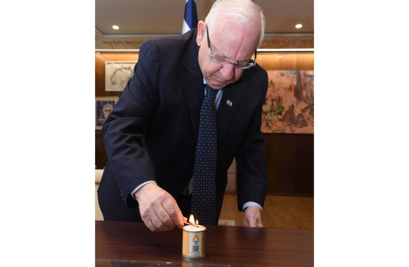 President Reuven Rivlin lighting a memorial candle from Our 6 Million (photo credit: MARC NEYMAN/GPO)
