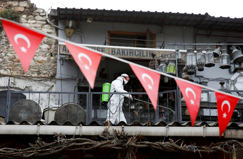PHOTO DE DOSSIER: Un travailleur en tenue de protection vaporise un désinfectant au Grand Bazar, connu sous le nom de Bazar couvert, pour prévenir la propagation de la maladie à coronavirus (COVID-19), à Istanbul, Turquie, le 25 mars 2020 (crédit photo: REUTERS / UMIT BEKTAS / FILE PHOTO)