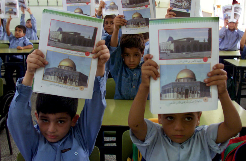 Palestinian children holding textbooks showing the al-Aqsa mosque in Jerusalem. (photo credit: REUTERS/REUTERS STAFF)