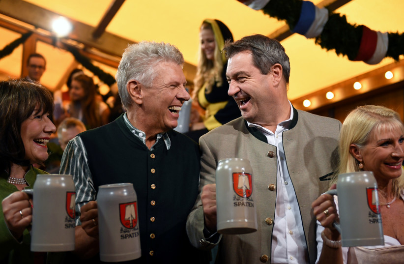 Munich mayor Dieter Reiter with his wife Petra and Bavarian State Prime Minister Markus Soeder with his wife Karin Baumueller hold beer at the opening day of the 186th Oktoberfest in Munich, Germany September 21, 2019. (photo credit: ANDREAS GEBERT/REUTERS)