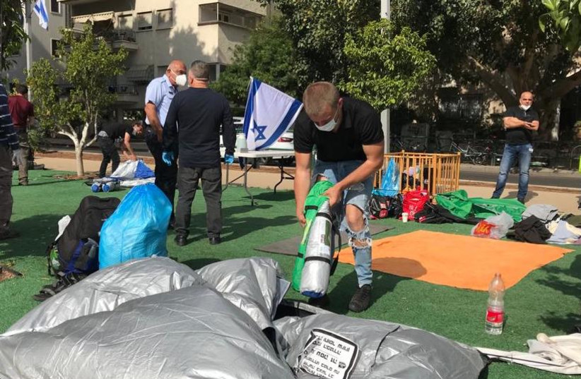 Costa Black, a restaurant manager from Eilat, packs away his tent on Rothschild Boulevard, Tel Aviv, April 26, 2020   (photo credit: AVSHALOM SASSONI)