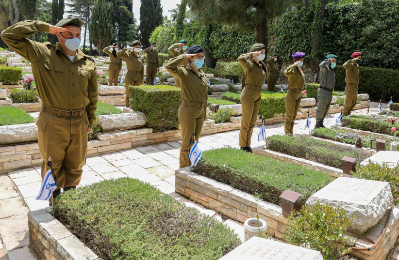 Soldiers saluting graves ahead of Israel's Memorial Day at Mount Hertzl (photo credit: MARC ISRAEL SELLEM/THE JERUSALEM POST)
