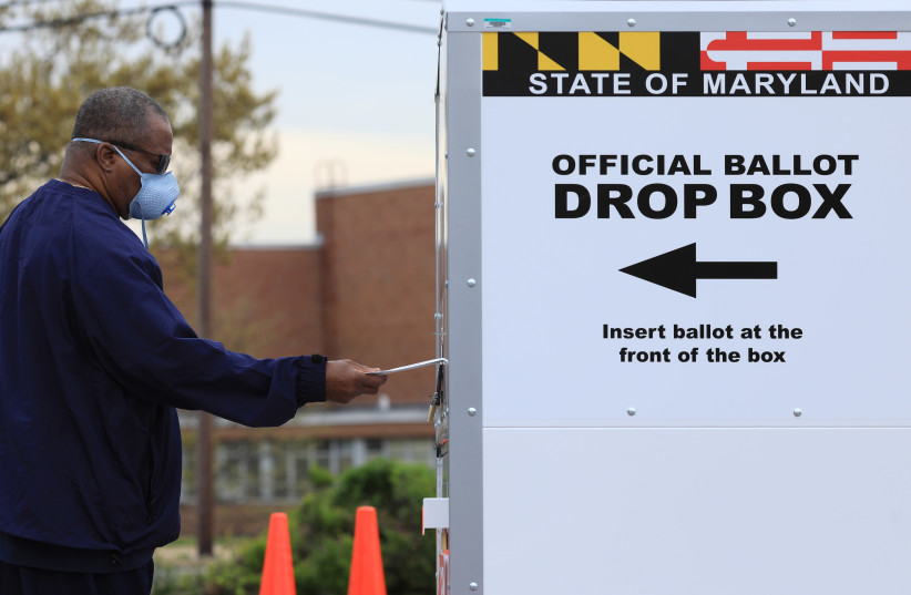 A resident drops off a mail-in ballot during the special election for Maryland's 7th congressional district seat, Maryland, U.S., April 28, 2020. (photo credit: REUTERS//TOM BRENNER)