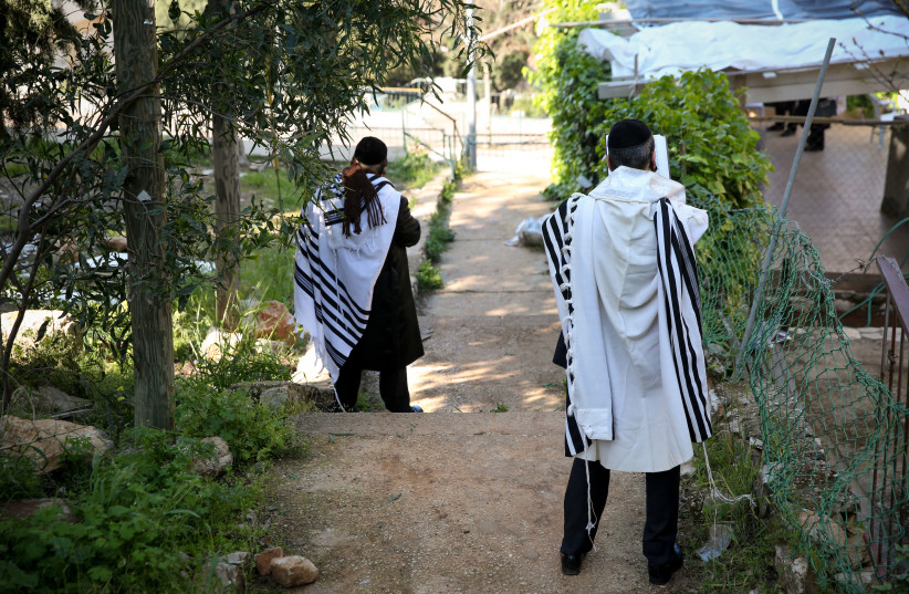 MEN DRAPED in tallitot pray outside their homes in Safed on April 13. (photo credit: DAVID COHEN/FLASH 90)