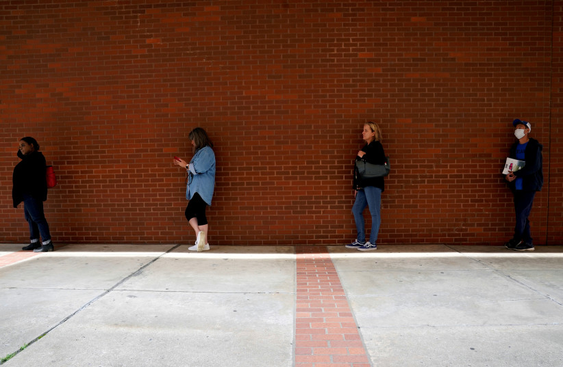 FILE PHOTO: People who lost their jobs wait in line to file for unemployment benefits, following an outbreak of the coronavirus disease (COVID-19), at Arkansas Workforce Center in Fort Smith, Arkansas, U.S. April 6, 2020 (photo credit: REUTERS/NICK OXFORD/FILE PHOTO)
