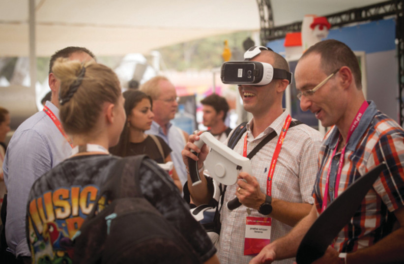PARTICIPANTS AT the DLD Tel Aviv Digital Conference, Israel’s largest international hi-tech gathering, featuring hundreds of start ups, VCs, angel investors and leading multinationals, get hands-on with some tech. (credit: MIRIAM ALSTER/FLASH90)