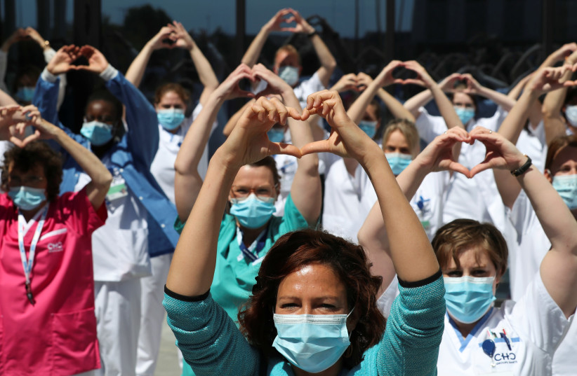 Healthcare workers, nurses and doctors, unified under the movement called "Take Care of Care" wearing face masks gesture during a protest against the Belgian authorities' management of the coronavirus disease (COVID-19) crisis, at the MontLegia CHC Hospital in Liege, Belgium, May 15, 2020. (photo credit: REUTERS)