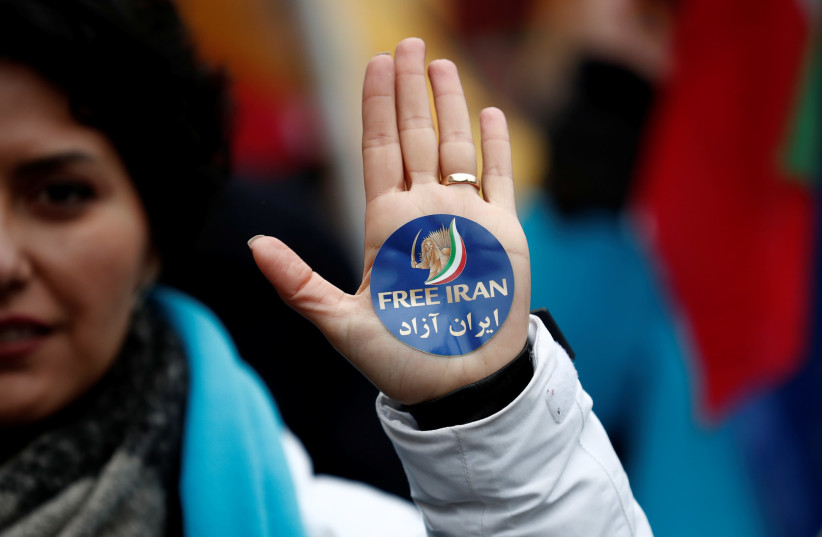 A woman displays a "Free Iran" sticker as thousands of Iranian opponents in exile stage a protest against the Teheran regime. Paris, France, February 8, 2019 (photo credit: BENOIT TESSIER/REUTERS)