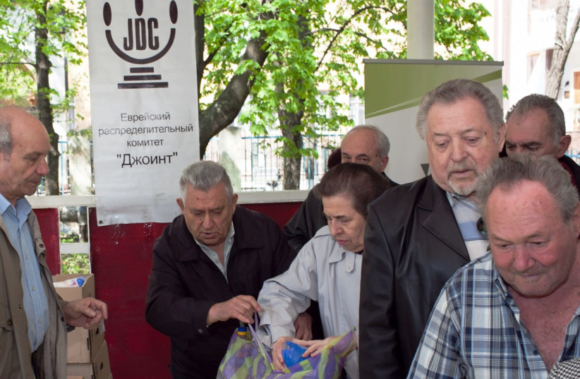 Elderly Ukrainians receive food packages at the Hesed social welfare center in Donetsk run by JDC (credit: COURTESY OF JDC/JTA)