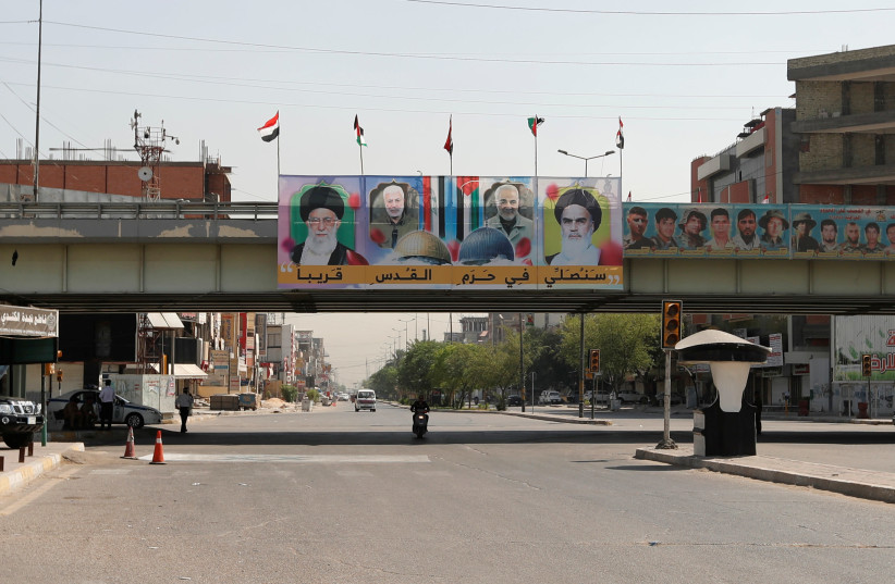 A banner hangs on a bridge on Palestine street showing pictures of Iran's supreme leader Ayatollah Ali Khamenei, the late Iranian general Qasem Soleimani, the late Iraqi commander Abu Mahdi al-Muhandis and the late founder of the Islamic Republic Ayatollah Ruhollah Khomeini, during the annual al-Qud (photo credit: REUTERS/THAIER AL-SUDANI)