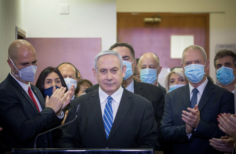 Likud MKs applaud Prime Minister Benjamin Netanyahu ahead of his first trial hearing on Sunday (photo credit: YONATAN SINDEL/FLASH90)