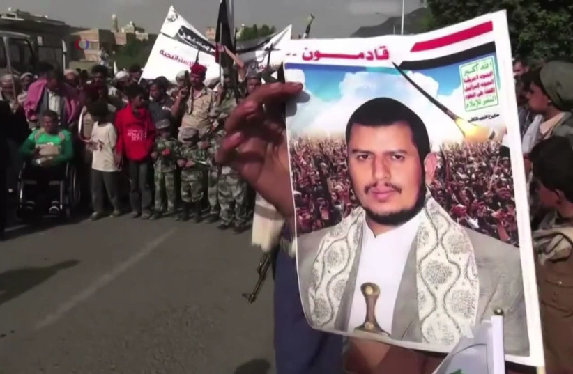 A Houthi holds up an image of Abdul-Malik Badreddin al-Houthi, the movement leader, during protests against the Saudi Arabian-led coalition (photo credit: WIKIPEDIA)