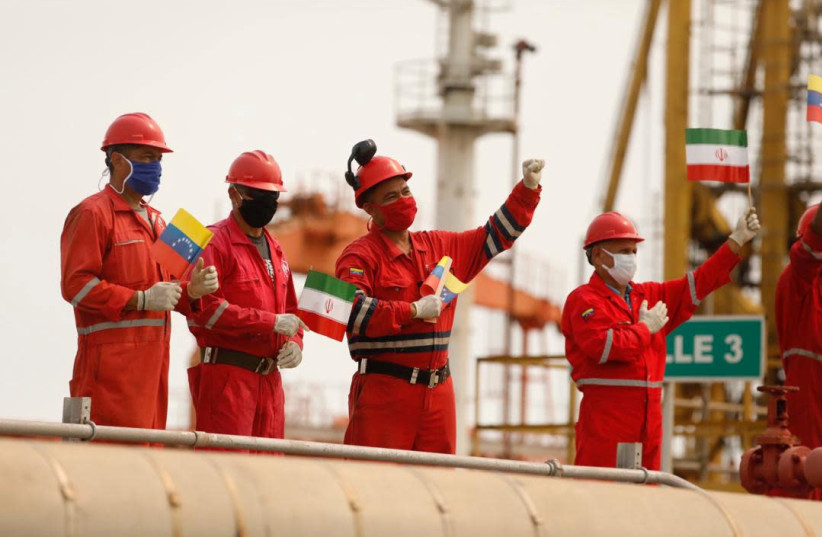 Workers of the state-oil company Pdvsa holding Iranian and Venezuelan flags greet during the arrival of the Iranian tanker ship ''Fortune'' at El Palito refinery in Puerto Cabello, Venezuela May 25, 2020 (credit: MIRAFLORES PALACE/HANDOUT VIA REUTERS)