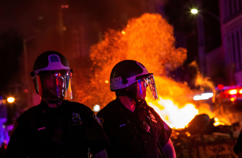 Les agents du NYPD montent la garde alors que la police tente de contrôler les manifestants pendant le pillage après avoir marché contre la mort dans la garde à vue de George Floyd à Minneapolis, dans le quartier de Manhattan à New York, États-Unis, le 1er juin 2020. (crédit photo: EDUARDO MUNOZ / REUTERS)