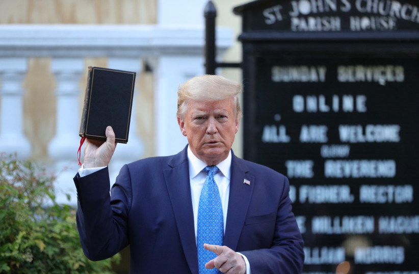 US President Donald Trump holds up a Bible in front of St. John's Episcopal Church, June 1, 2020. (photo credit: REUTERS//TOM BRENNER)