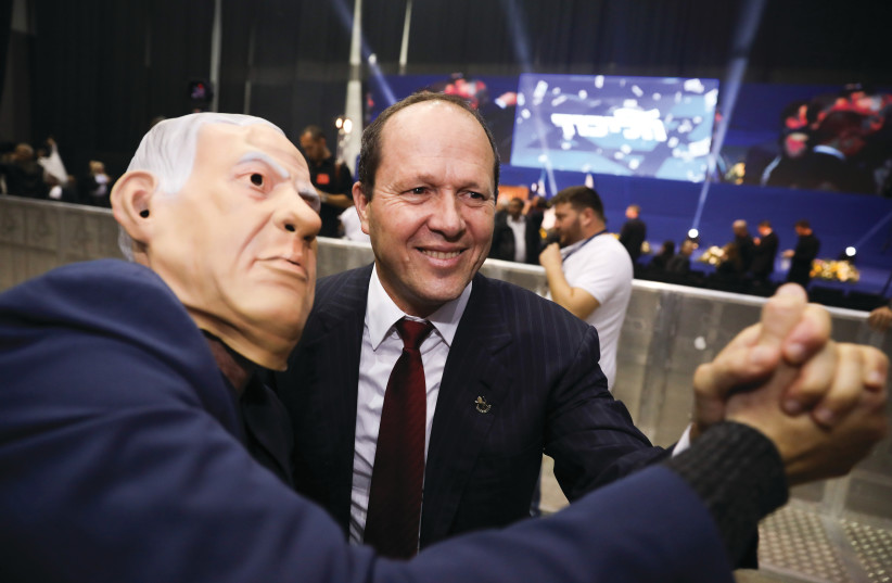 BARKAT TAKES an election-night photo with a Bibi-masked man at Likud Party headquarters in Tel Aviv on March 2. (photo credit: OLIVIER FITOUSSI/FLASH90)
