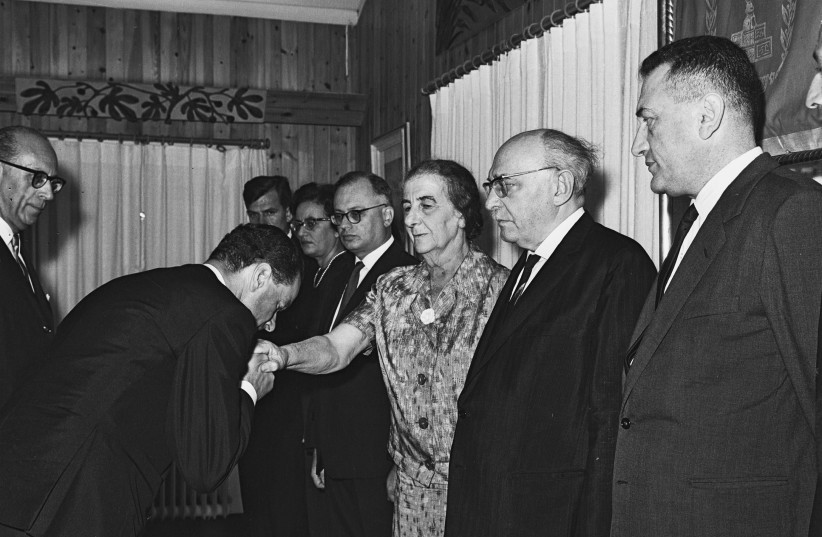 GERMAN AMBASSADOR Rolf Pauls kisses the hand of foreign minister Golda Meir, after presenting his credentials at the President’s Residence in Jerusalem in 1965. (photo credit: MOSHE PRIDAN / GPO)