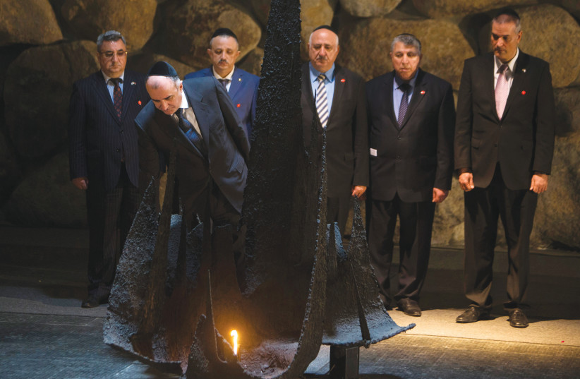 AZERBAIJAN FOREIGN MINISTER Elmar Mammadyarov rekindles the eternal flame during a ceremony in Jerusalem. (photo credit: REUTERS/Ronen Zvulun)