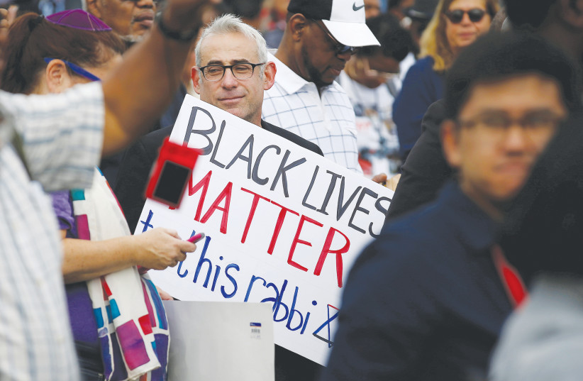 BLACK LIVES matter to Jews. A rabbi carries a sign supporting Black Lives Matter at a rally in Washington. (photo credit: REUTERS/JOSHUA ROBERTS)