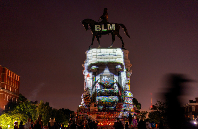 An image of George Floyd is projected on the statue of Confederate General Robert E. Lee in Richmond, Virginia, U.S. June 20, 2020 (photo credit: REUTERS)