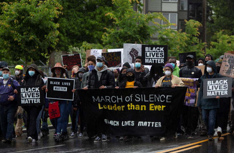 Protesters walk in the rain down 23rd Avenue South in Seattle on June 12 during a silent march organized by Black Lives Matter to protest against racial inequality in the aftermath of the death of George Floyd  (credit: REUTERS/LINDSEY WASSON)