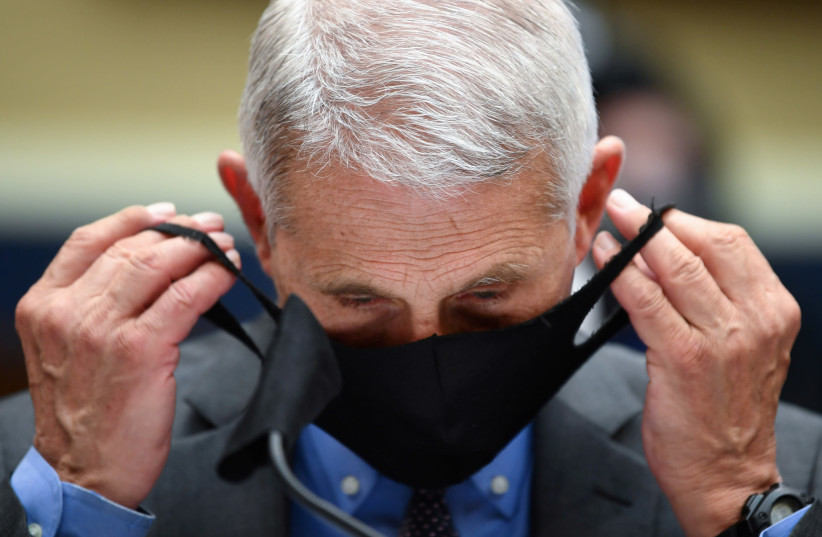 Director of the National Institute for Allergy and Infectious Diseases Dr. Anthony Fauci takes off his face mask prior testifying before the House Committee on Energy and Commerce on the Trump Administration's Response to the COVID-19 Pandemic, on Capitol Hill in Washington, DC, U.S. June 23, 2020 (photo credit: REUTERS)