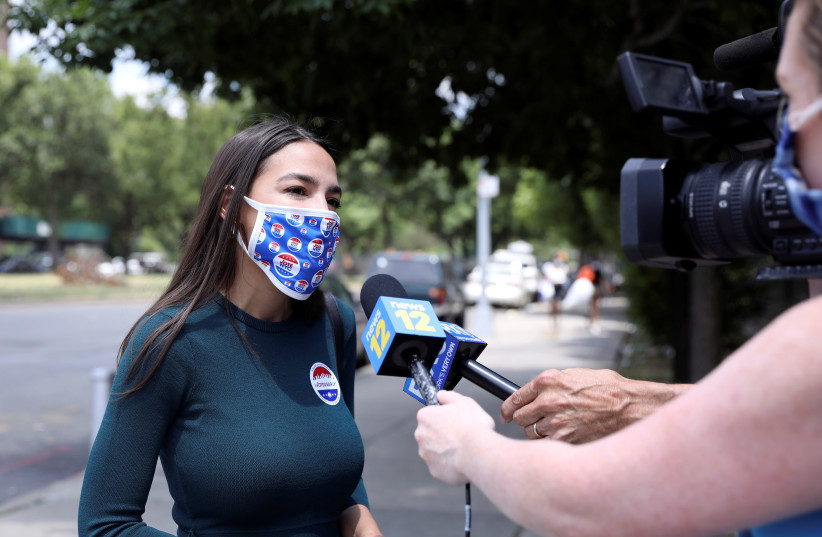 U.S. Rep. Alexandria Ocasio-Cortez (D-NY), answers questions from journalists after voting early in the Democratic congressional primary election at the Justice Sonia Sotomayor Community Center in the Bronx borough of New York City, U.S., June 20, 2020 (photo credit: REUTERS/CAITLIN OCHS)
