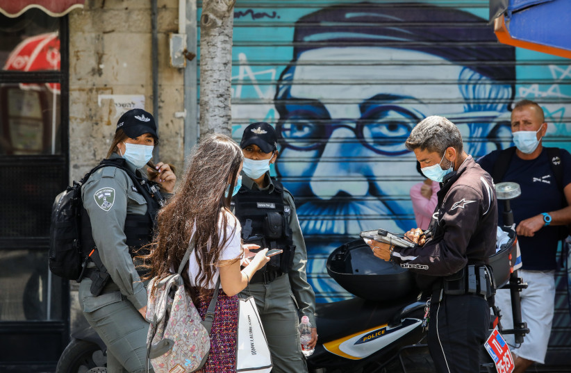 Israel Police officers giving out tickets for not wearing a mask in public (photo credit: MARC ISRAEL SELLEM/THE JERUSALEM POST)