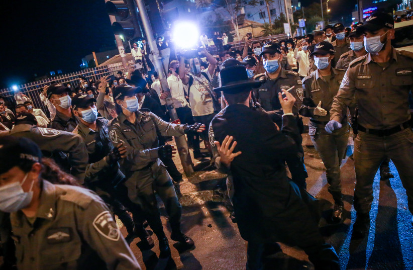 Ultra orthodox jewish men and youth seen during a protest against the closure on the Romema and Kiryat Belz neighborhoods in Jerusalem that is currently under a lock down in an attempt to prevent the spread of the Coronavirus, on July 12, 2020. (photo credit: FLASH90)