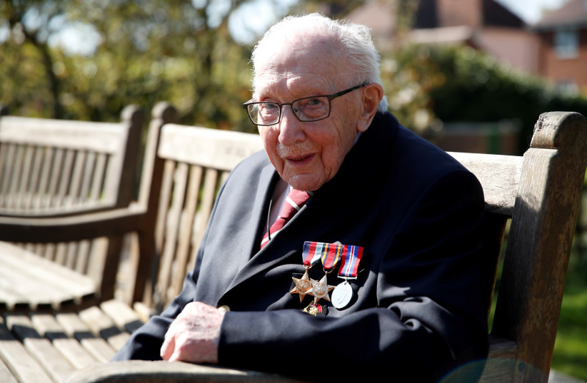Retired British Army Captain Tom Moore, 99, poses after he continued to raise money for health workers, by attempting to walk the length of his garden one hundred times before his 100th birthday this month as the spread of coronavirus disease (COVID-19) continues, Marston Moretaine, Britain, April 1 (photo credit: REUTERS/PETER CZIBORRA)