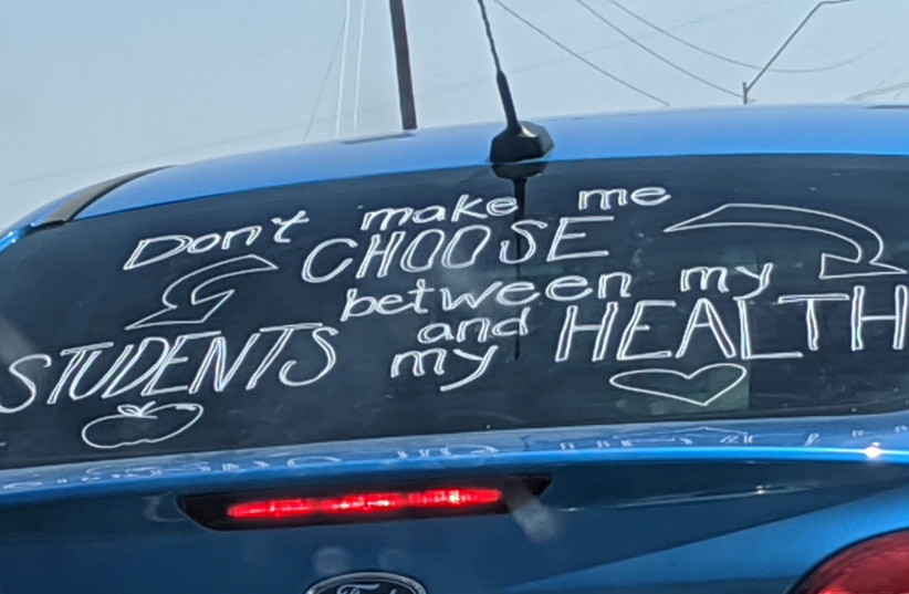A slogan is seen on a car in "a motor march” protest of teachers who took it to their vehicles to demand a delay in in-person learning in the fall, due to the coronavirus disease (COVID-19) outbreak, in Phoenix, Arizona, U.S., July 15, 2020. Picture taken July 15, 2020. (photo credit: REUTERS/KELLEY FISHER NO RESALES. NO ARCHIVES)
