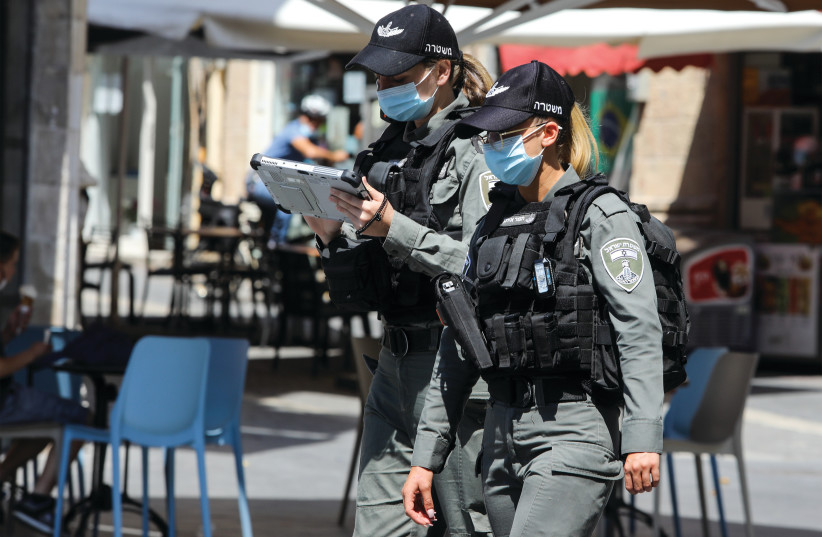 Two police officers patrol downtown Jerusalem to ensure that people are wearing masks (photo credit: MARC ISRAEL SELLEM)