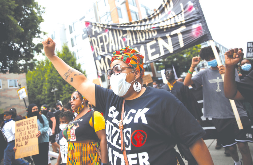 A PROTESTER in Seattle during a Juneteenth march commemorating the end of slavery. We are now reaping the harvest of the seeds of racism and discrimination – the devaluation of black life. (photo credit: LINDSEY WASSON/REUTERS)