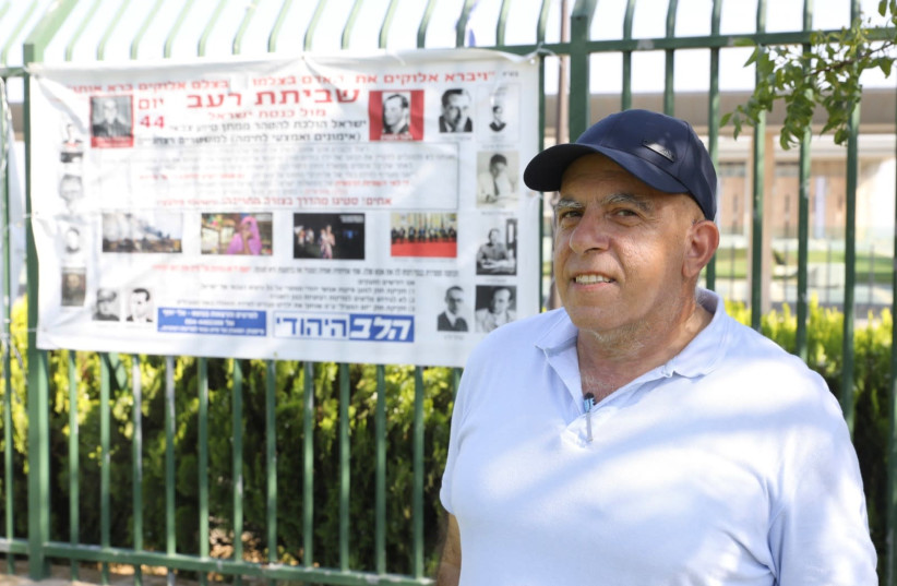 Elie Joseph in front of his banner protesting Israeli arms sales to major human rights violators, Jerusalem, July 2020 (photo credit: MARC ISRAEL SELLEM/THE JERUSALEM POST)