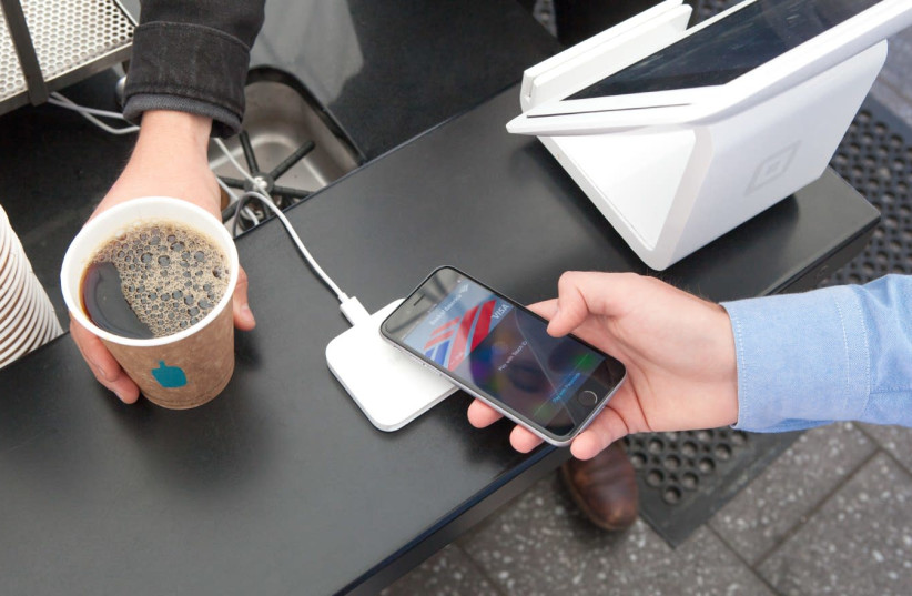 A gentleman paying for coffee with an iPhone 6 with Square's apple pay and EMV reader. (photo credit: WIKIPEDIA)