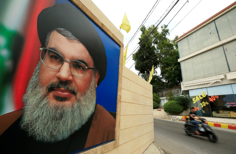 A man rides a motorbike past a picture of Lebanon's Hezbollah leader Sayyed Hassan Nasrallah, near Sidon. (photo credit: ALI HASHISHO/REUTERS)