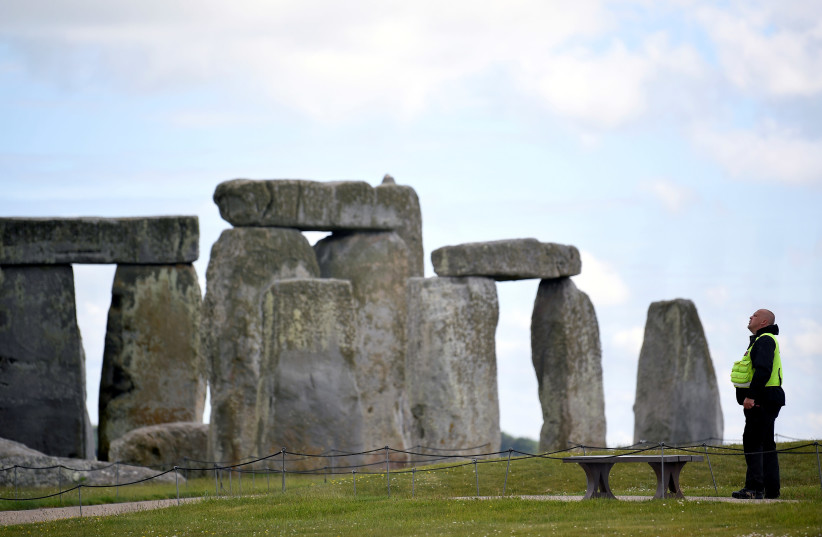 FILE PHOTO: A security officer patrols around the perimeter Stonehenge stone circle, where official Summer Solstice celebrations were cancelled due to the spread of the coronavirus disease (COVID-19), near Amesbury, Britain June 20, 2020 (photo credit: REUTERS/TOBY MELVILLE/FILE PHOTO)