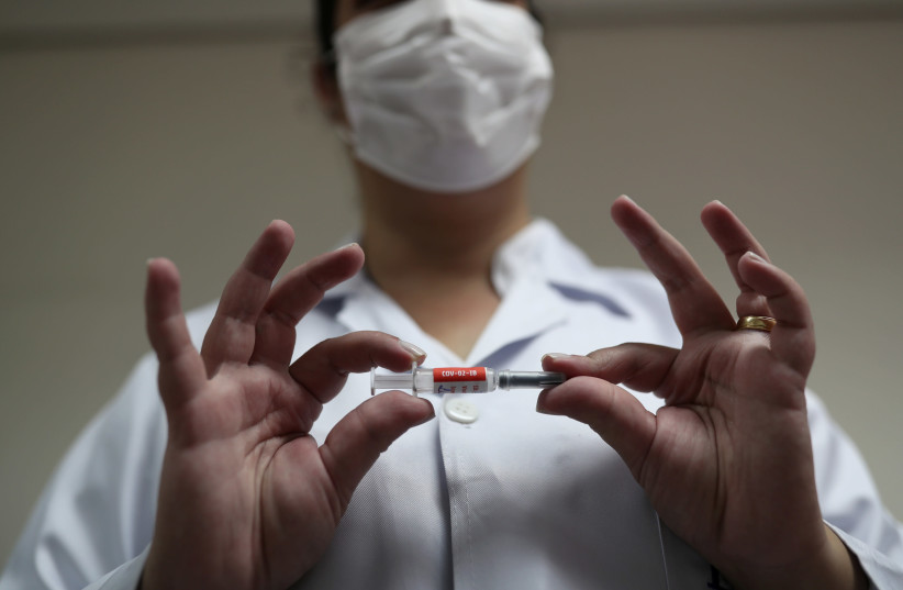 A nurse holds China's SinoVac coronavirus potential vaccine for trials before administering it to a volunteer at Emilio Ribas Institute in Sao Paulo, Brazil July 30, 2020.  (photo credit: REUTERS/AMANDA PEROBELLI)