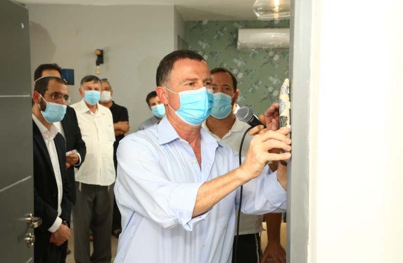 Health Minister Yuli Edelstein hangs a mezuzah at a new Migron home (photo credit: DAVID WEIL PHOTOGRAPHY)