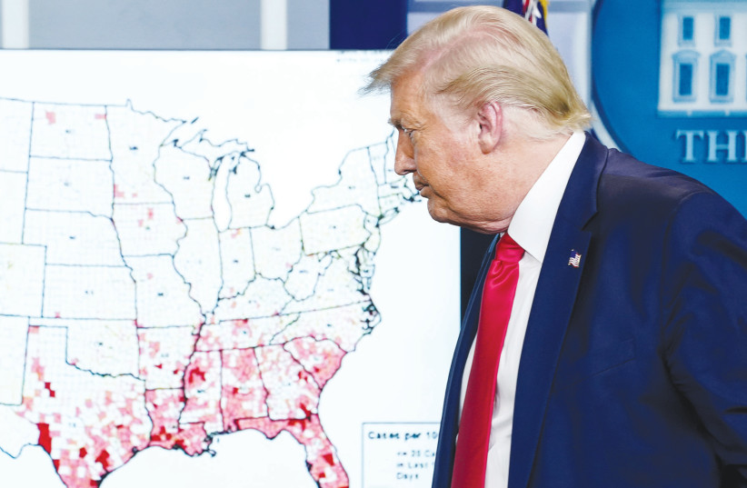 US PRESIDENT Donald Trump walks past a map of reported coronavirus cases following a news briefing at the White House on July 23. (photo credit: KEVIN LAMARQUE/REUTERS)