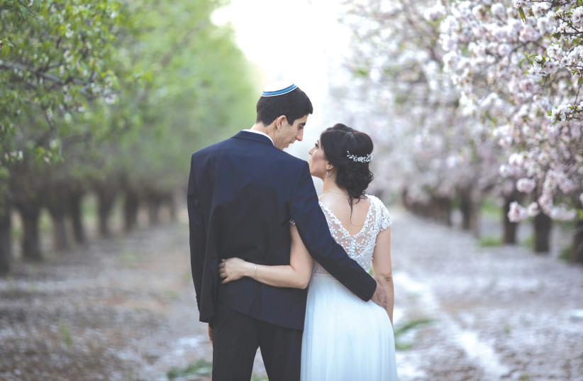 A NEW bride and groom visit a blossoming almond grove in Latrun on their wedding day in 2019. (credit: HADAS PARUSH/FLASH90)
